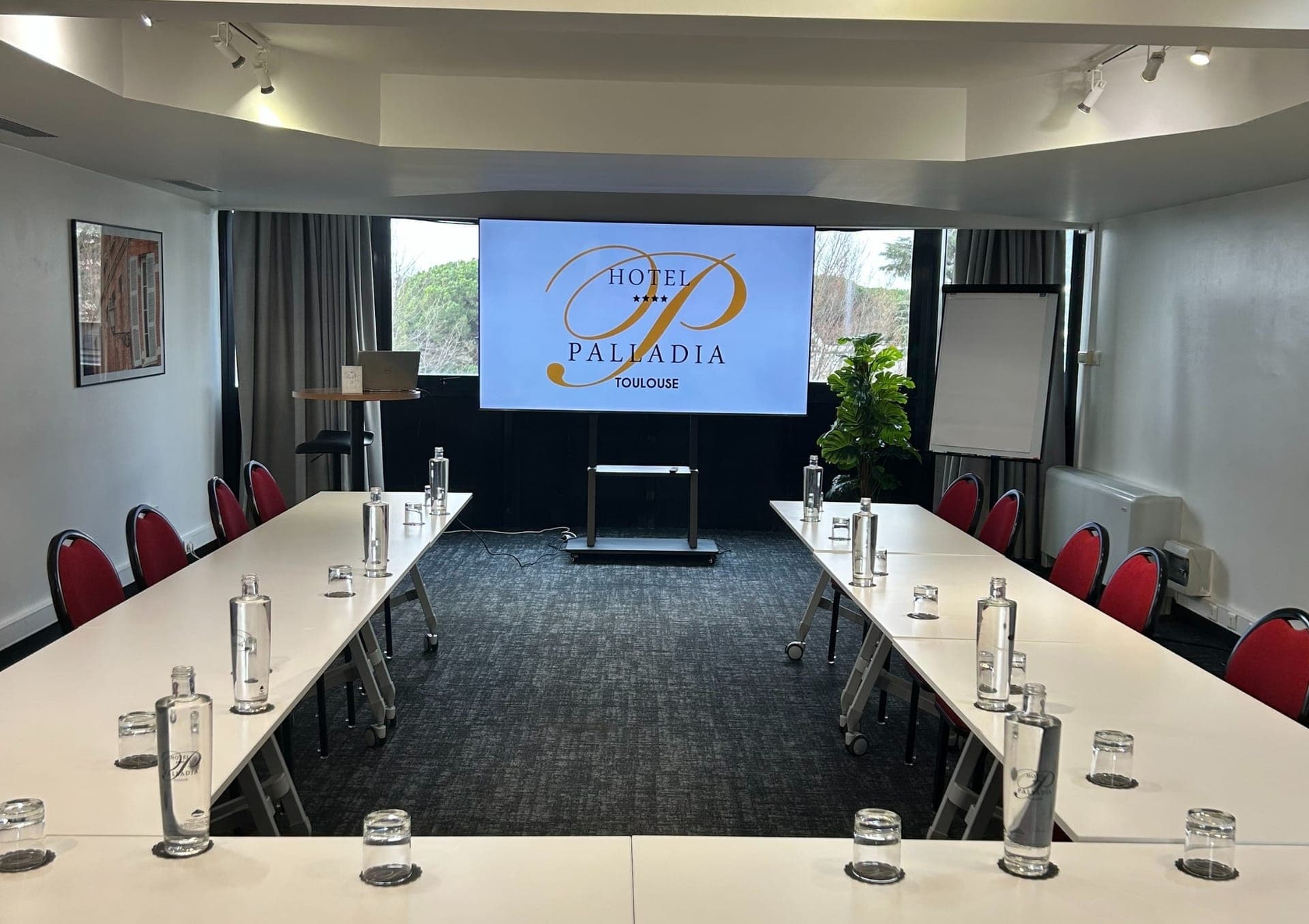 A training room at the Hôtel Palladia fitted with a screen and a flip chart