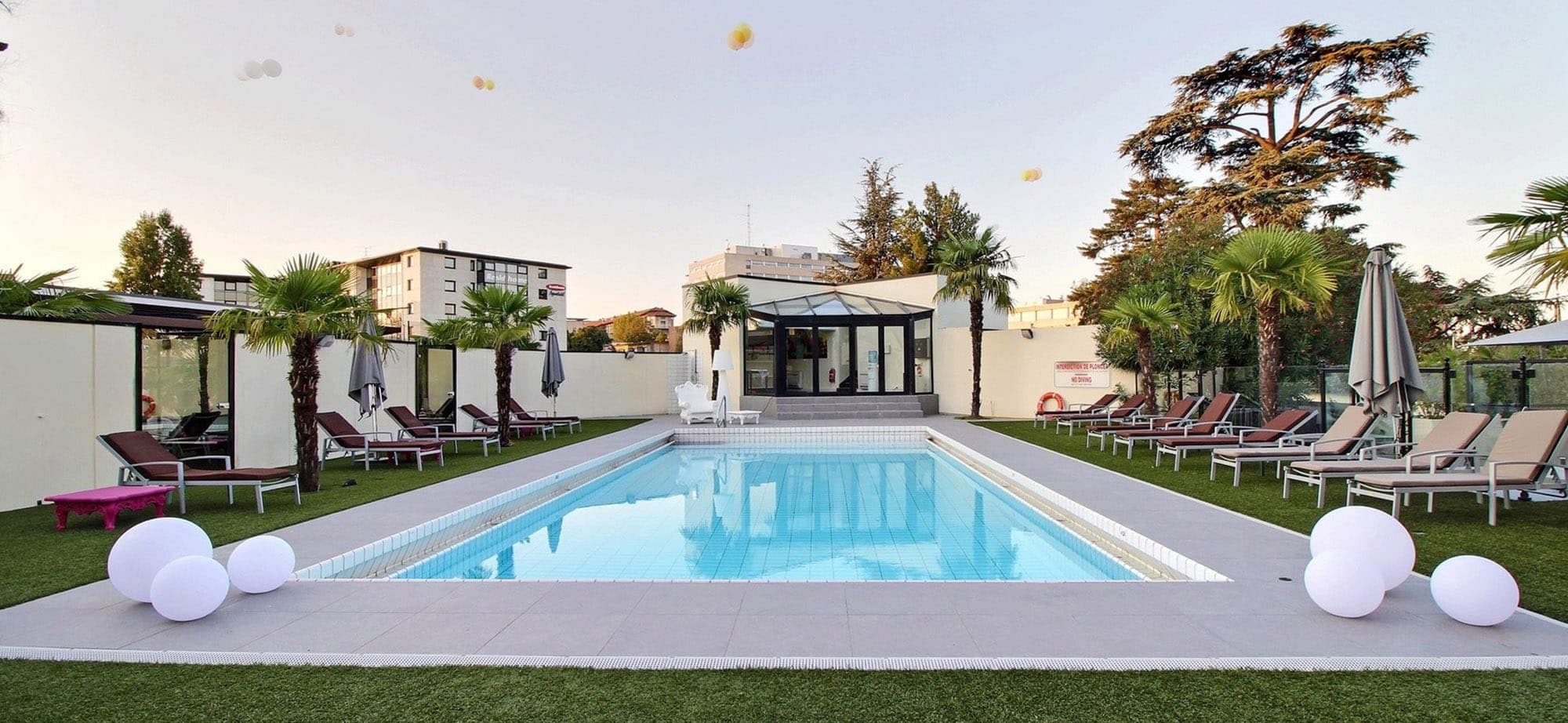 La piscina exterior del Hôtel Palladia al anochecer