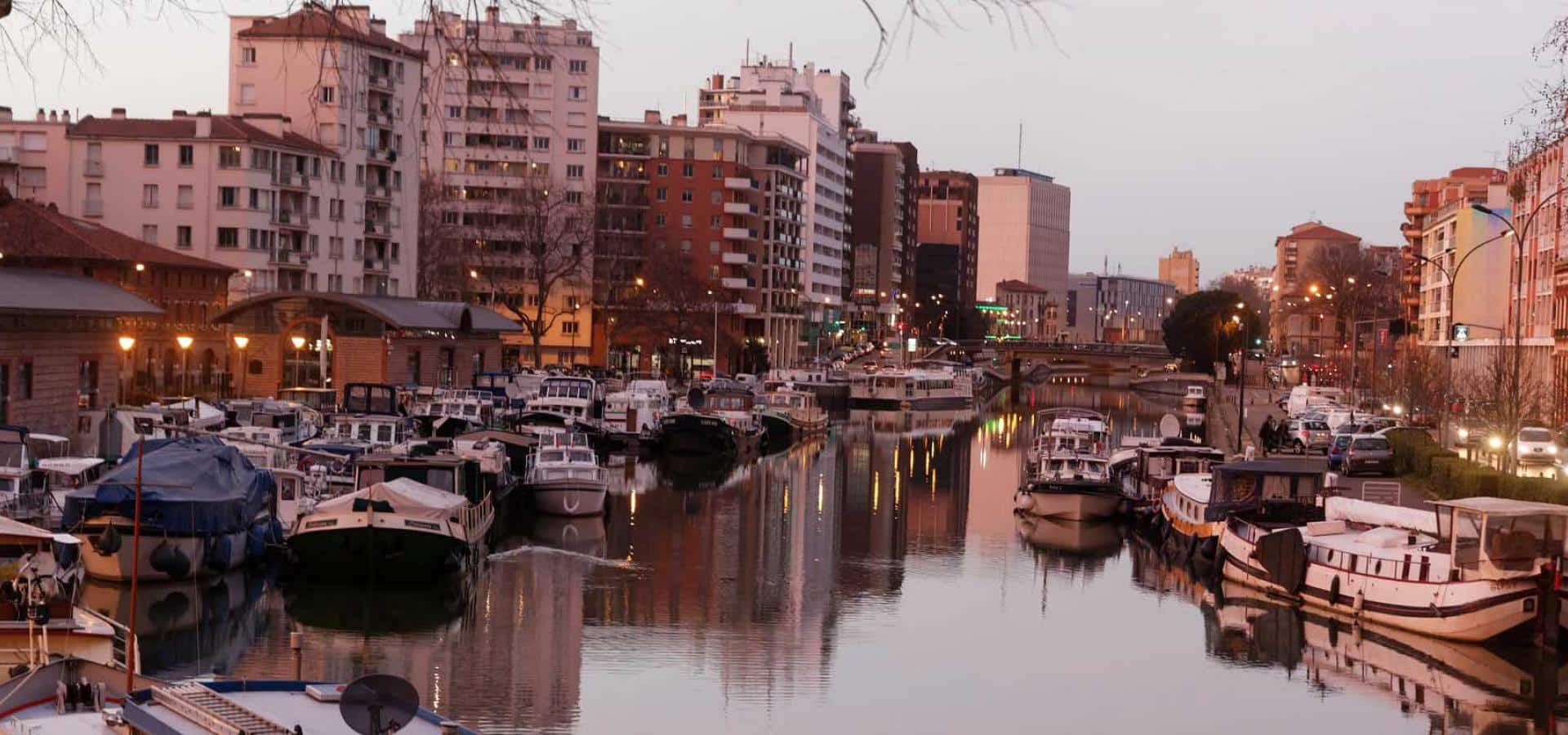 Port Saint-Sauveur in Toulouse at dusk, barges moored along the canal
