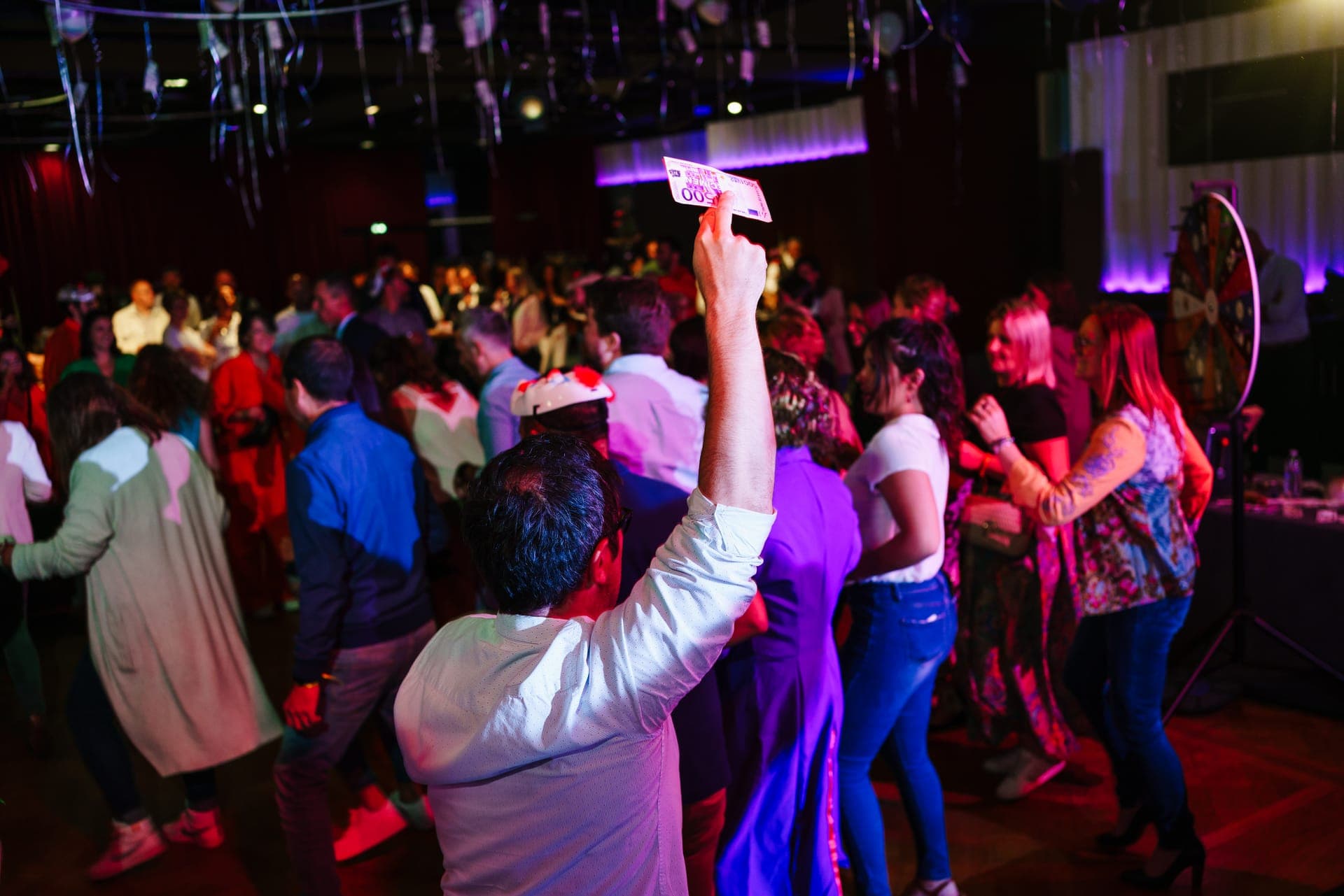 Participantes en la pista de baile junto a una ruleta de casino durante una fiesta de empresa en el Hôtel Palladia