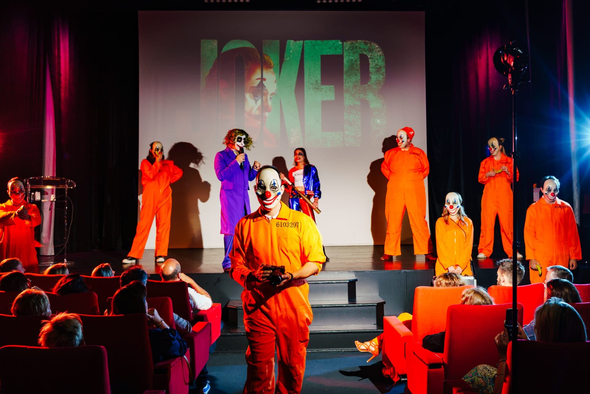 Actores disfrazados en el escenario del auditorio durante una fiesta temática del Joker